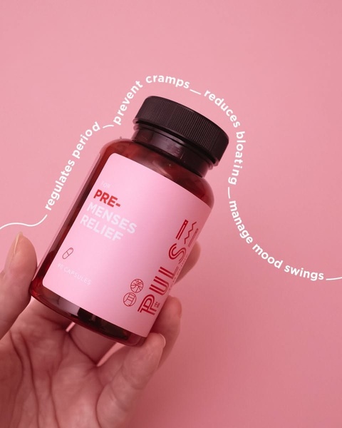 A close-up product shot of a supplement bottle with handwritten-style annotations detailing specific health benefits for menstrual relief.